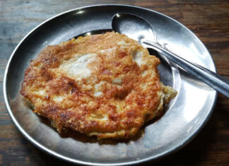 Bara – Kathmandu, Nepal | Eat Your World Bara, a Newari lentil pancake on a metal plate, from a cafe in Kathmandu.