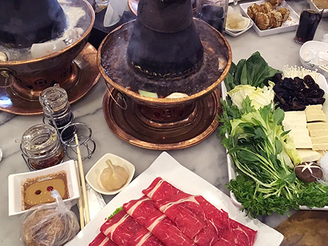 Beijing-style hot pot, or shuan rou, using a miniature coal-burning stove with chimney. 