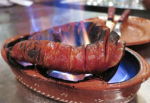 Chourico assado – Lisbon, Portugal Flaming chourico assado in a traditional clay bowl from a Lisbon fado bar.