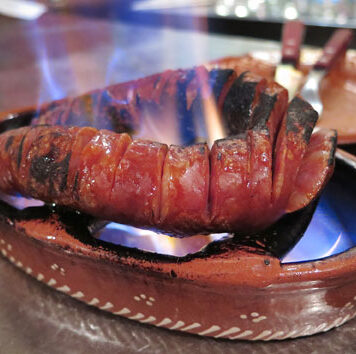 Chourico assado – Lisbon, Portugal Flaming chourico assado in a traditional clay bowl from a Lisbon fado bar.
