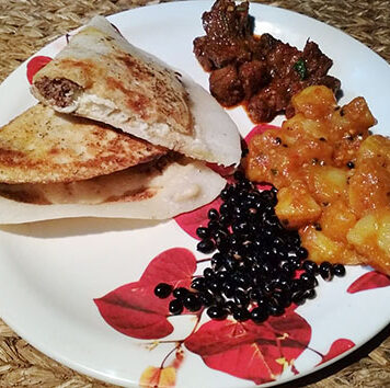 Chatamari in Kathmandu, Nepal | Eat Your World A plate of chatamari, Nepali crepe, with some sides of beans, potatoes, and meat from Kathmandu.