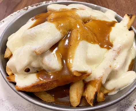 A plate of disco fries, french fries smothered in mozzarella cheese and gravy, from a New Jersey diner.